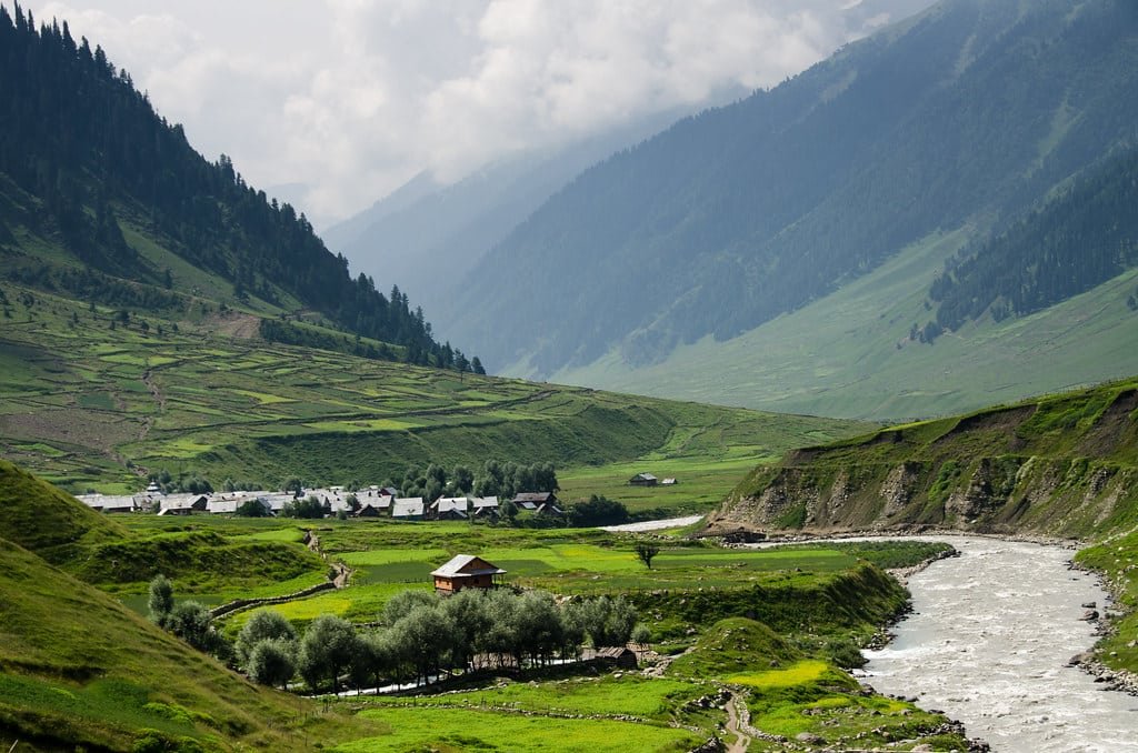 River flowing through a warwan valley with mountains and village houses