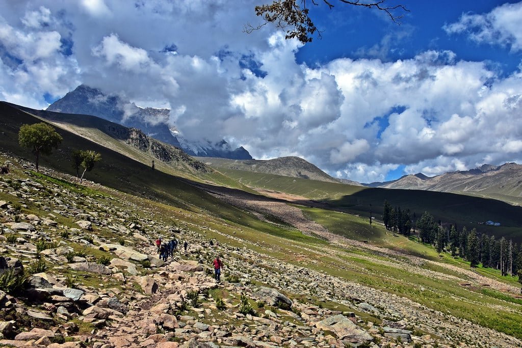 People trekking on a rocky path in the mountains of Narang Valley in Kashmir.