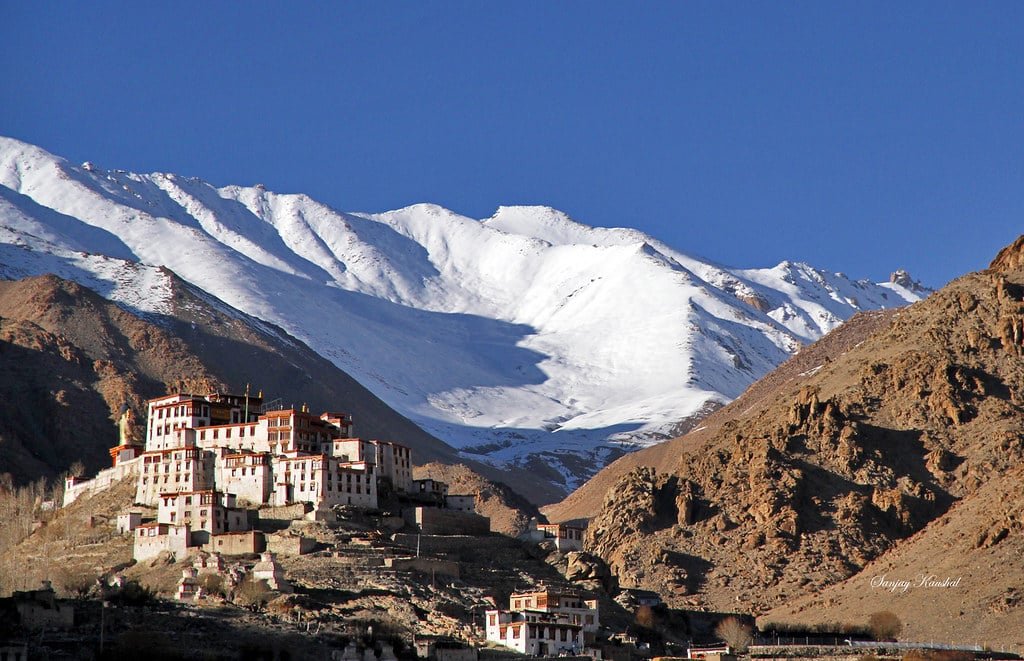 Likir Monastery with snow-covered mountains in the background.