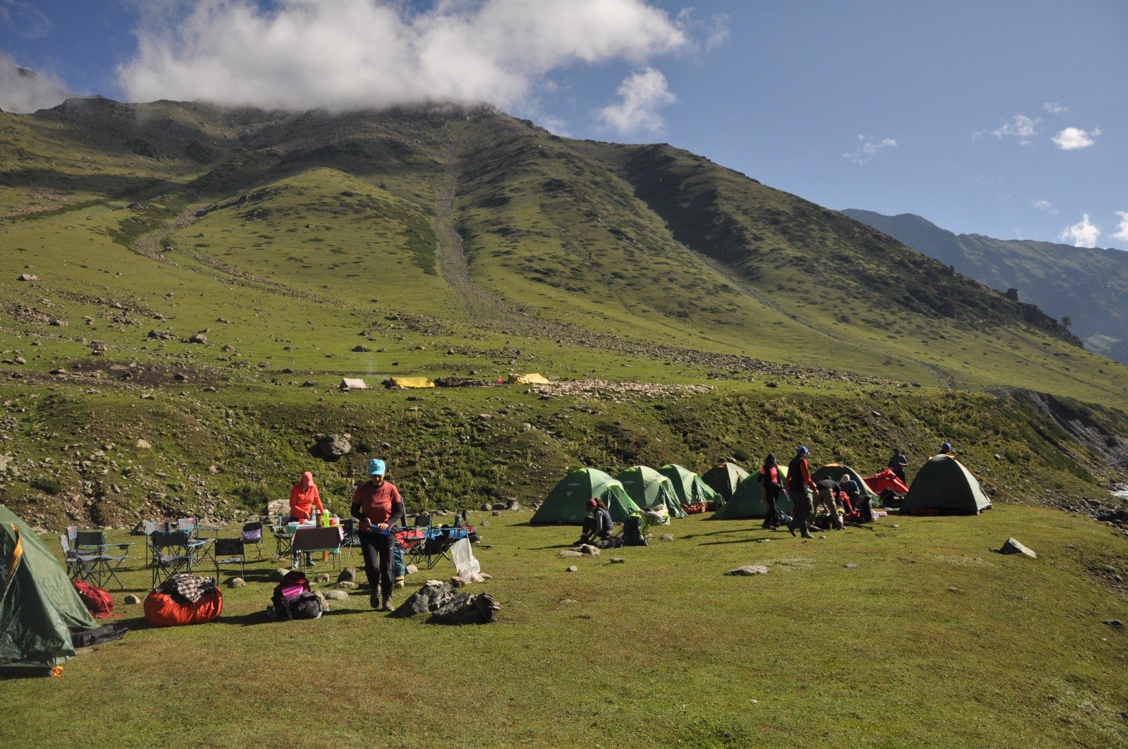 a campsite on tarsar marsar trek with tents and trekkers