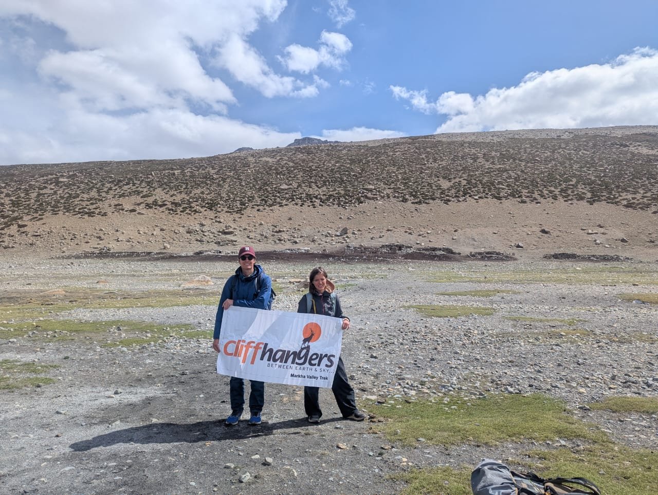 Trekkers holding the banner of cliffhangers on the Markha Valley trek