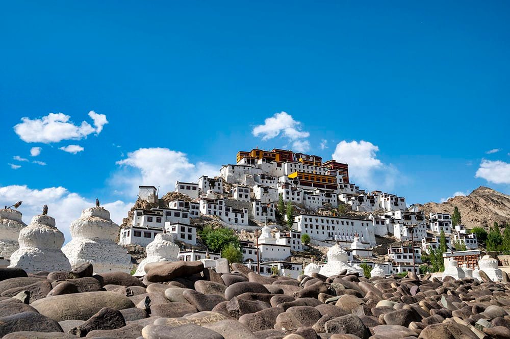 Thiksey Monastery on a hill with white buildings and blue sky