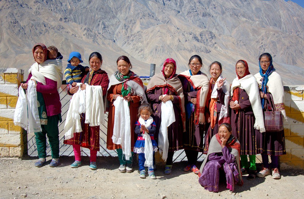 Group of women and children in traditional attire posing outdoors