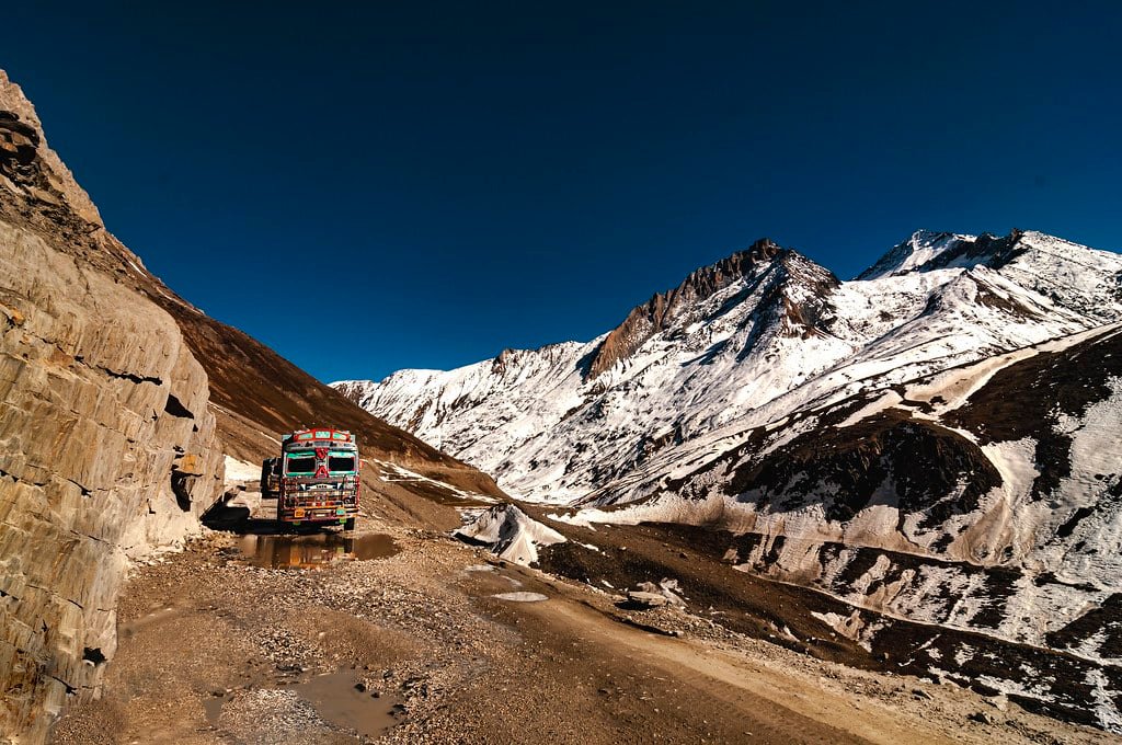 A truck driving through snowy mountain roads at Zoji La Pass​