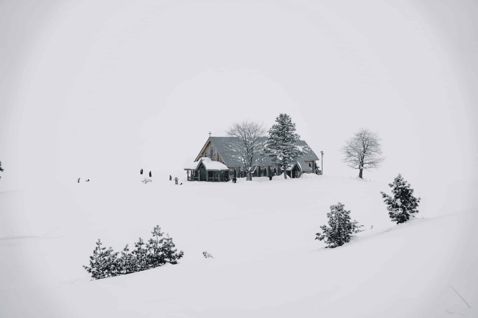 A small church surrounded by trees and deep snow in Gulmarg, Kashmir