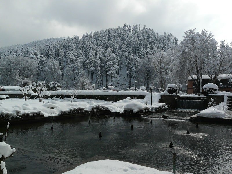 Snow-covered Achabal garden with frozen fountains and serene water channels