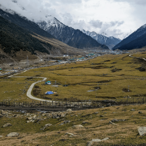 Winding road leading to a valley surrounded by snow-capped mountains at Zero Point, Sonmarg