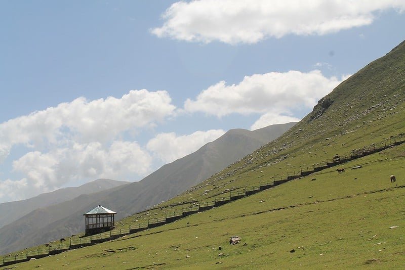 Green hill with fence and hut