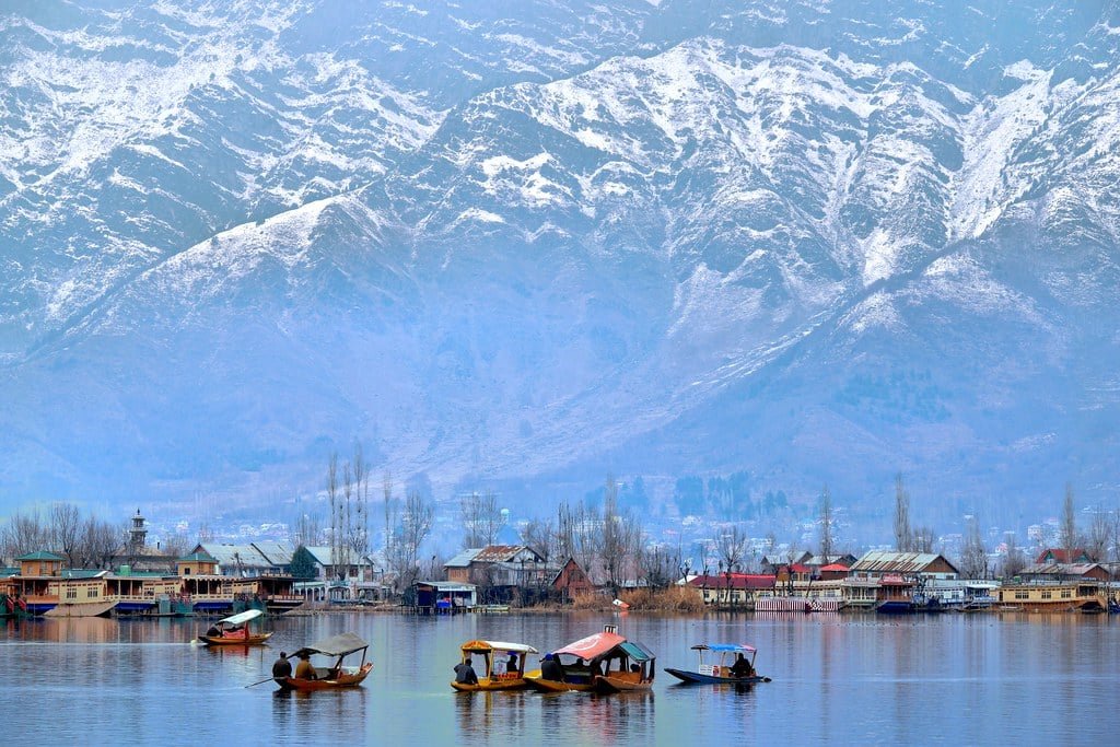Houseboat on dal Lake with snow-covered mountains in the background