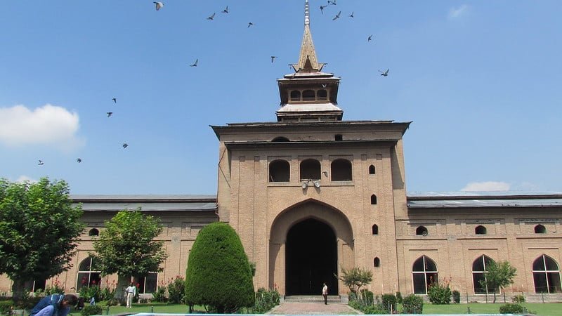 Historic mosque with brown brick architecture, arched entrance, in srinagar