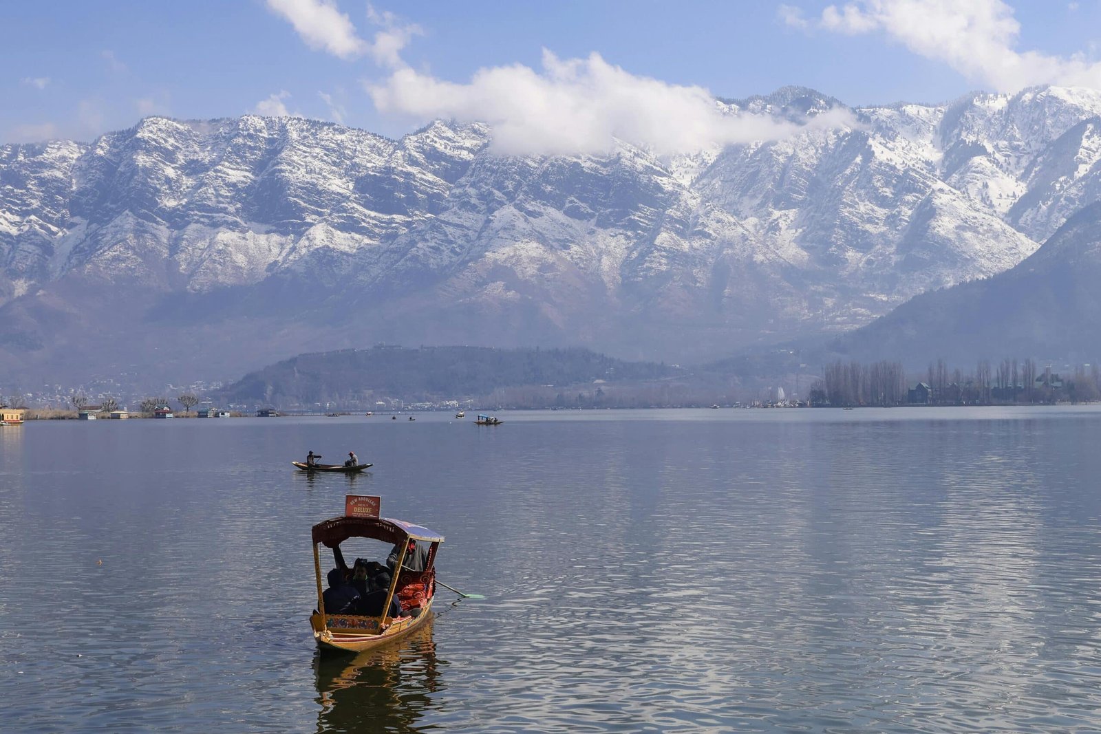 A shikara gliding over the serene Dal Lake in February