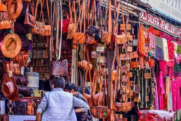 colorful market stall displaying handcrafted leather bags and accessories