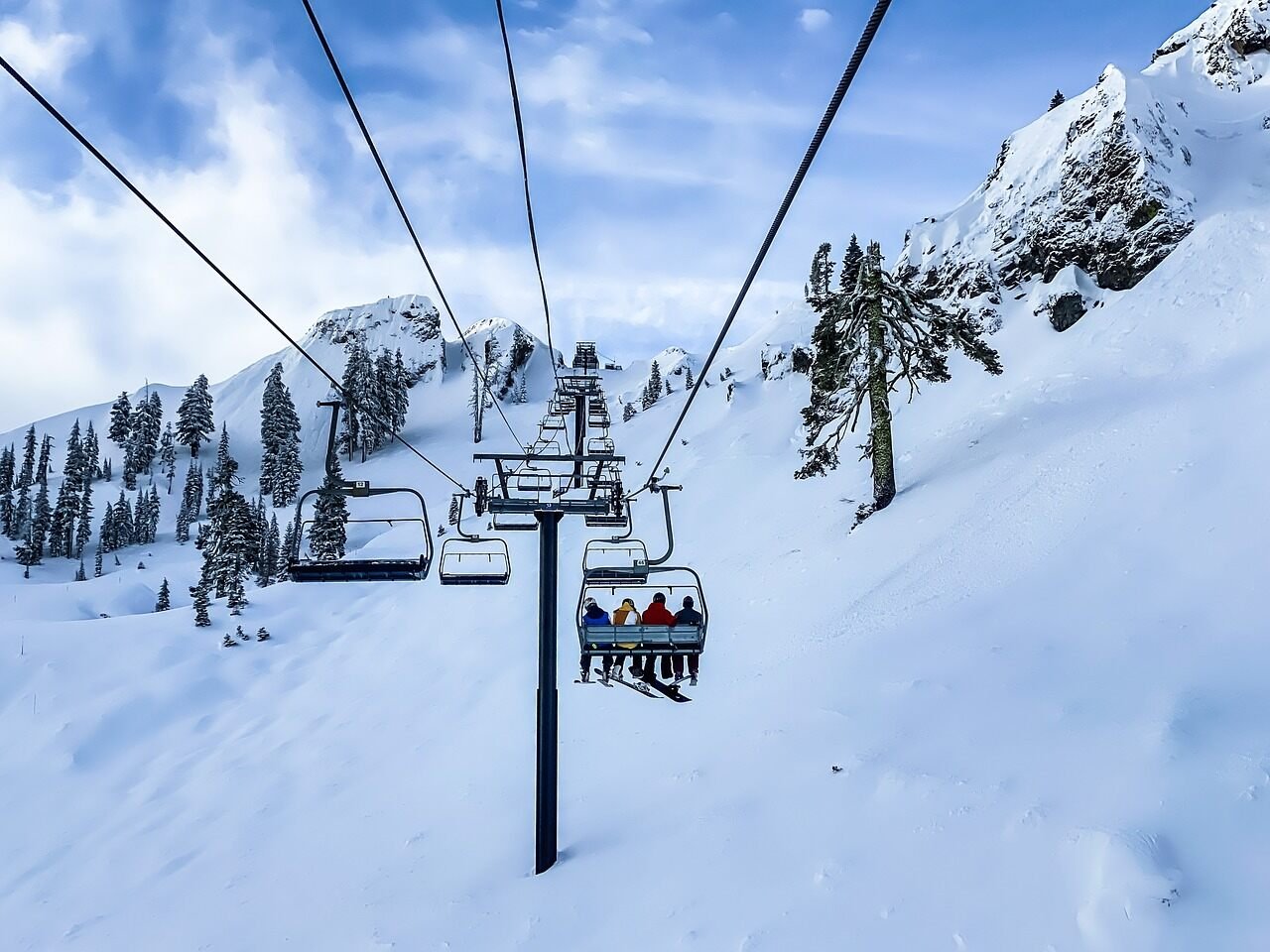 People riding Gulmarg Gondola chairlift amid in snow-covered mountains