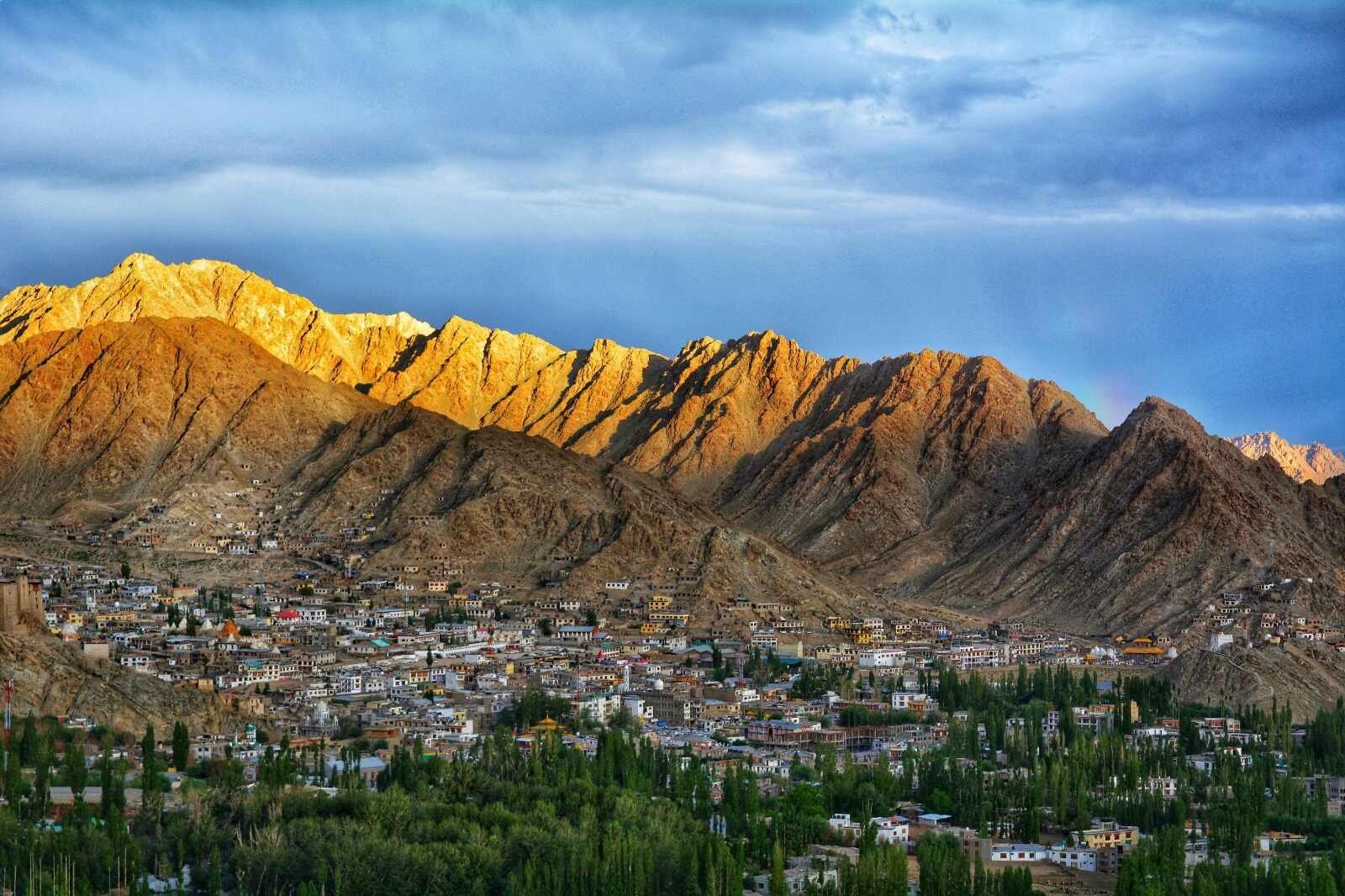 Leh town with mountains lit by golden sunlight.
