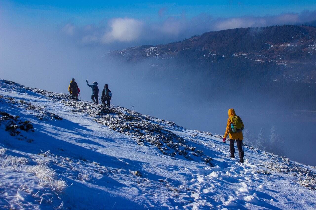 People trekking on a snow-covered mountain slope in kashmir
