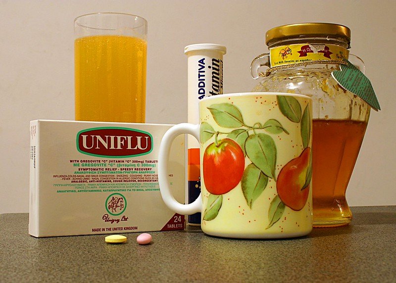 Cold and flu relief items including Uniflu, honey, vitamin C, and a mug