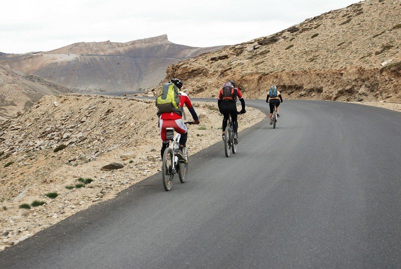 Cyclists riding through a mountain road near Leh.