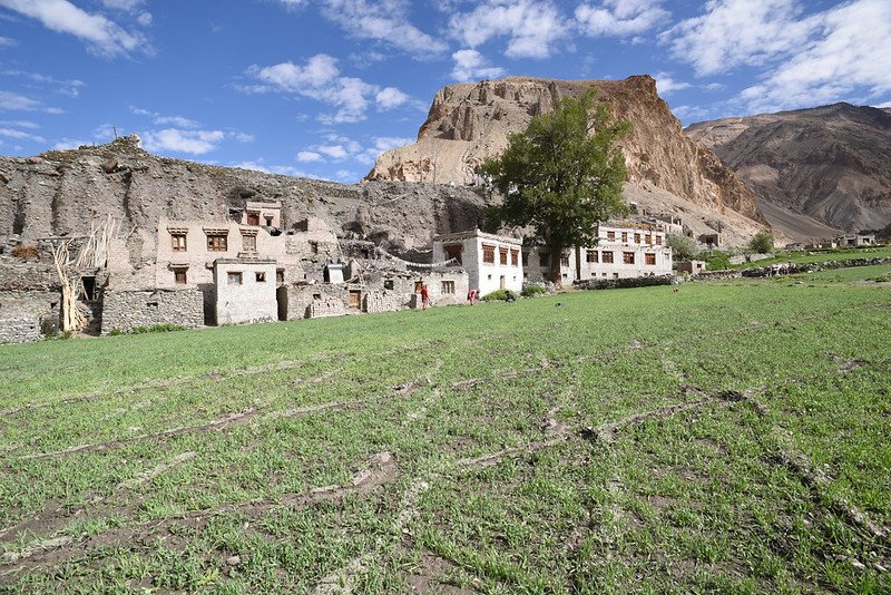 Traditional stone buildings of Zimskhang Museum with green fields and rocky hills