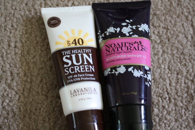 Two skincare tubes on carpet – one sunscreen and one moisturizer