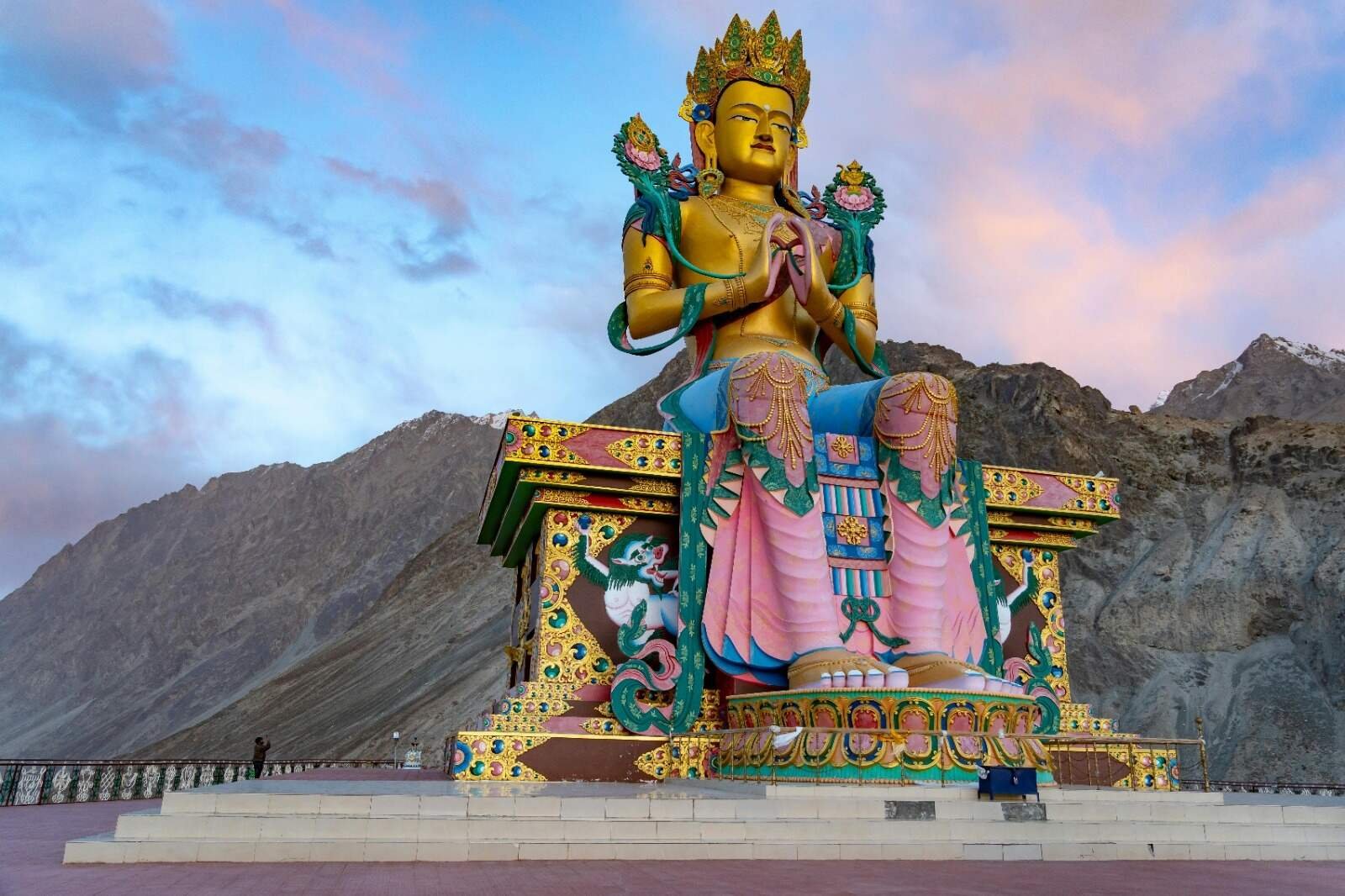 Large golden Maitreya Buddha statue at Diskit Monastery with mountains in the background