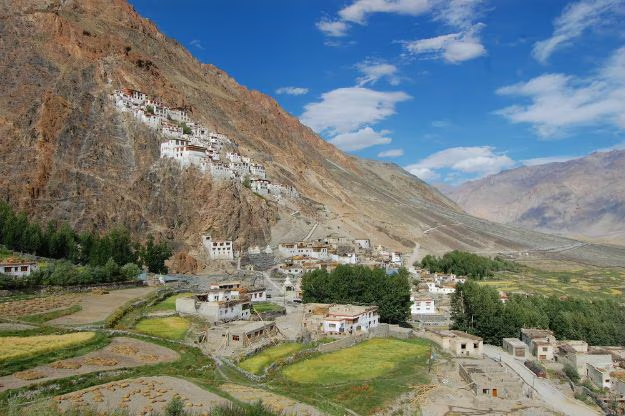Karsha Monastery on a cliff with village and fields below in padum valley