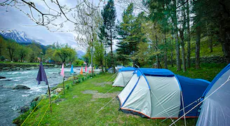Tents set up along the riverside for camping in Pahalgam
