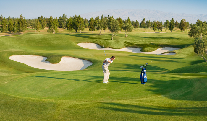 Golfing in Gulmarg on a green course with sand bunkers and trees