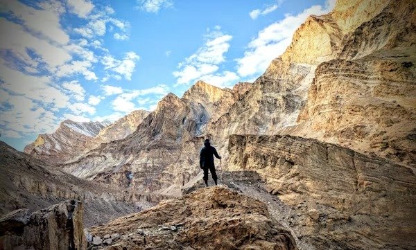 Person trekking in the rocky mountains of Ladakh under a bright sky