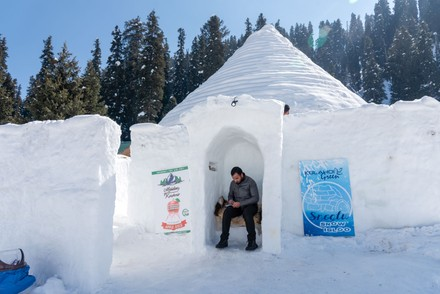 Man sitting at the entrance of the Igloo Café in snowy Gulmarg