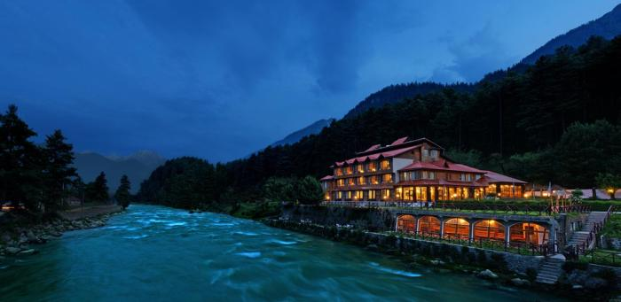Luxury riverside resort in Pahalgam at dusk